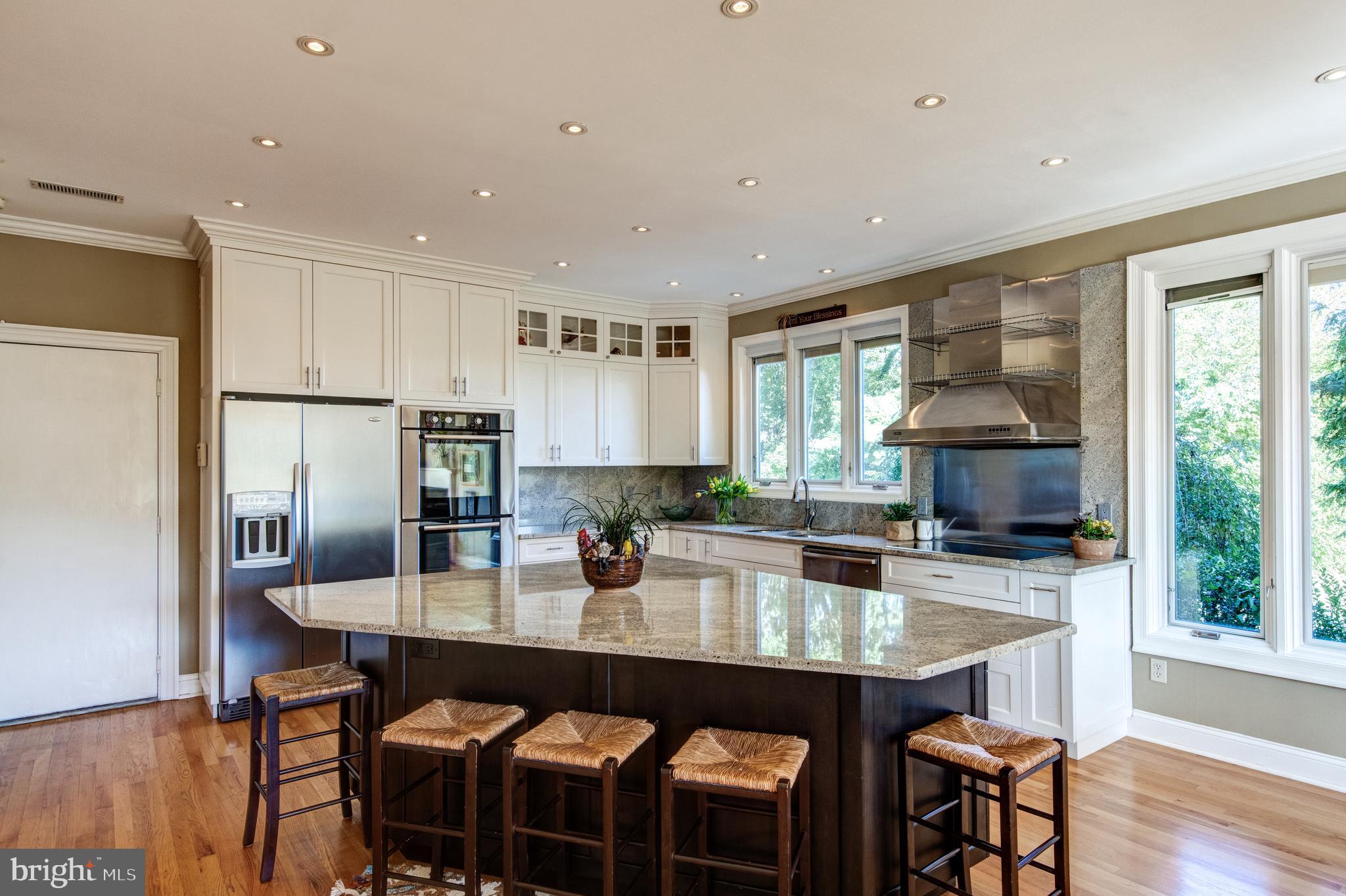 242 Ravenscliff Road Wayne, PA 19087 - Photo 9 of 49 a kitchen with granite countertop a table chairs stove and cabinets