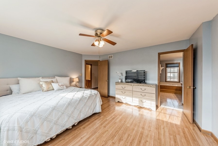 4539 Opal Drive Hoffman Estates, IL 60192 - Photo 12 of 27 a bedroom with a bed and a chandelier