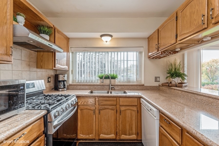 4539 Opal Drive Hoffman Estates, IL 60192 - Photo 7 of 27 a kitchen with kitchen island granite countertop a sink stove and cabinets