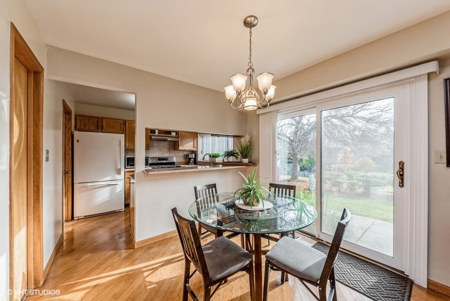 4539 Opal Drive Hoffman Estates, IL 60192 - Photo 9 of 27 a dining room with furniture a chandelier and wooden floor