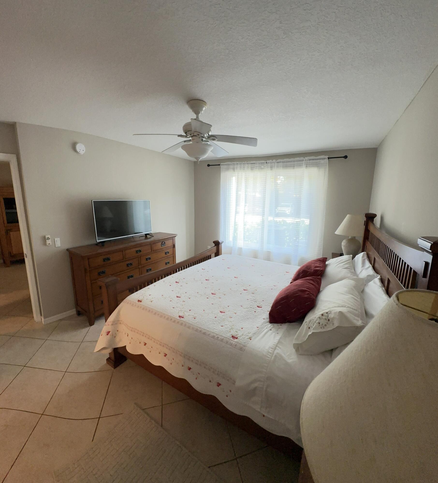 805 Villa Circle Boynton Beach, FL 33435 - Photo 10 of 21 a large bedroom with a bed and a flat screen tv