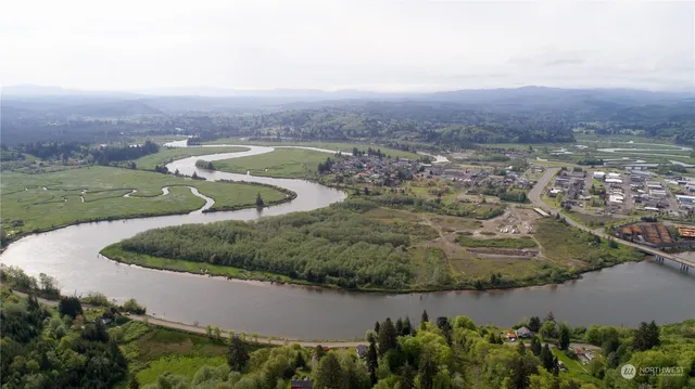 an aerial view of a house with a yard and lake view in back