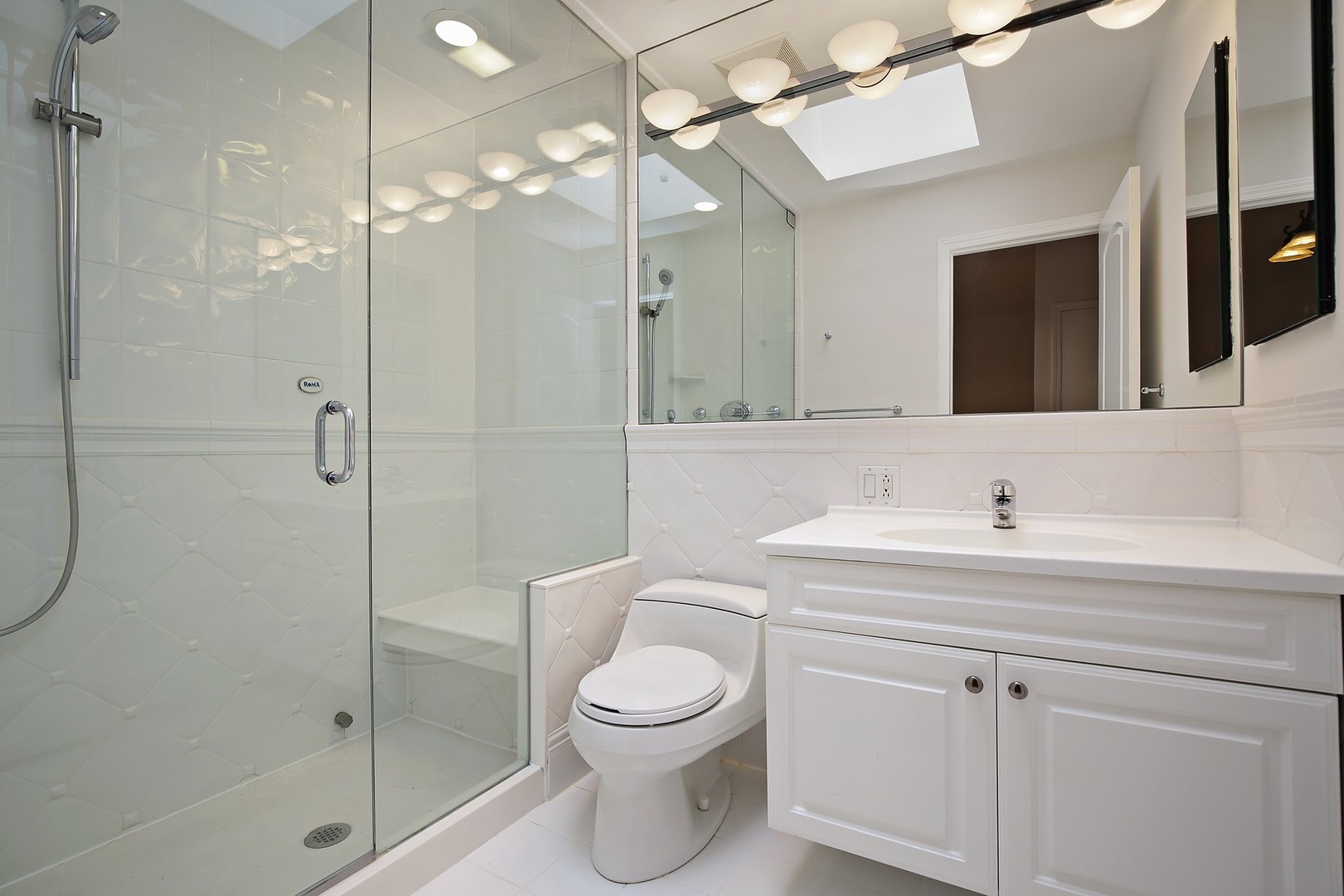 616 Dundee Road Glencoe, IL 60022 - Photo 14 of 22 a bathroom with a toilet sink vanity granite and shower