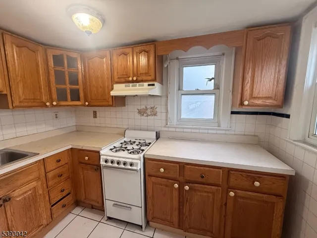 a kitchen with cabinets appliances a sink and a window