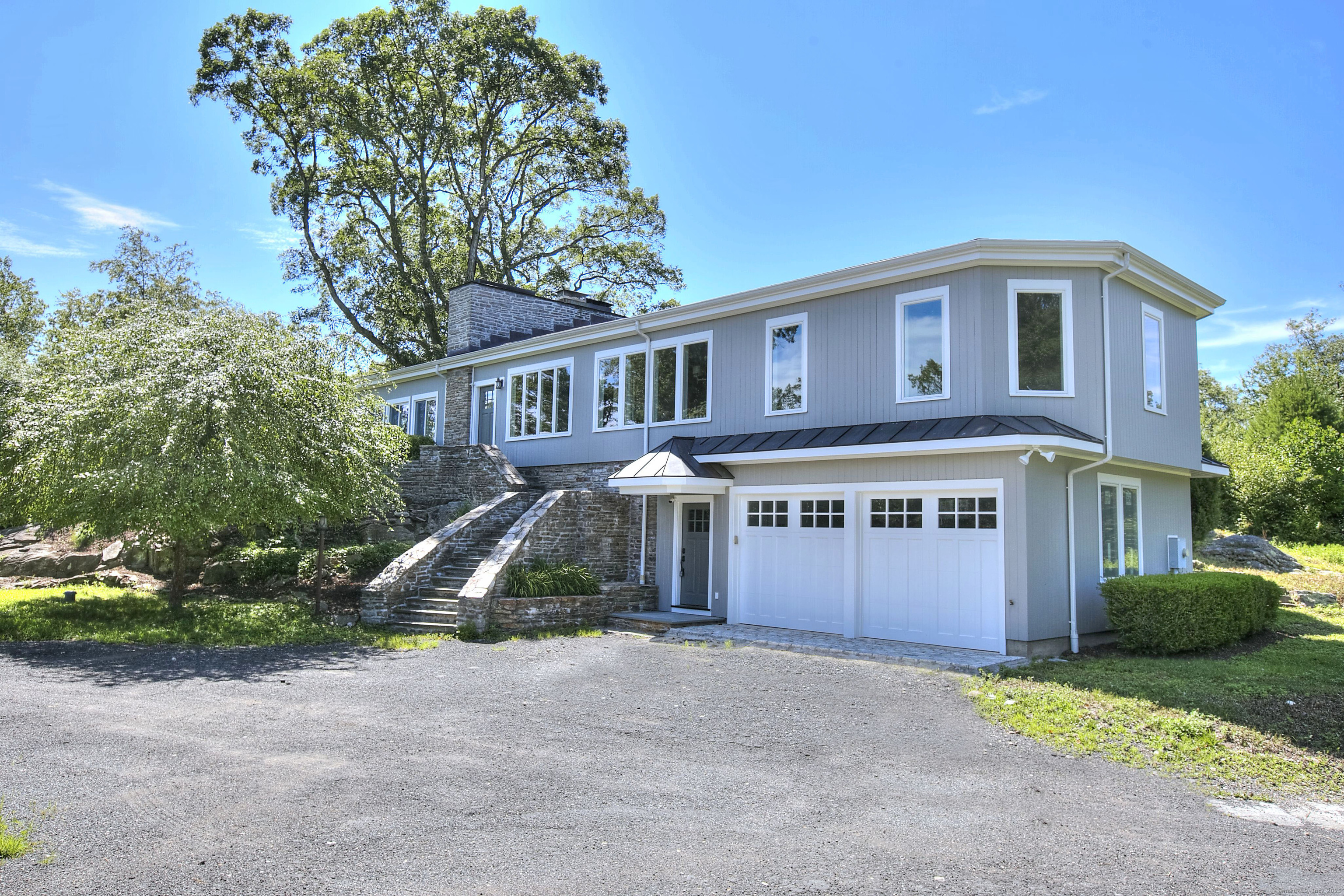 27 Rogues Ridge Road Weston, CT 06883 - Photo 1 of 39 a front view of a house with a yard and garage