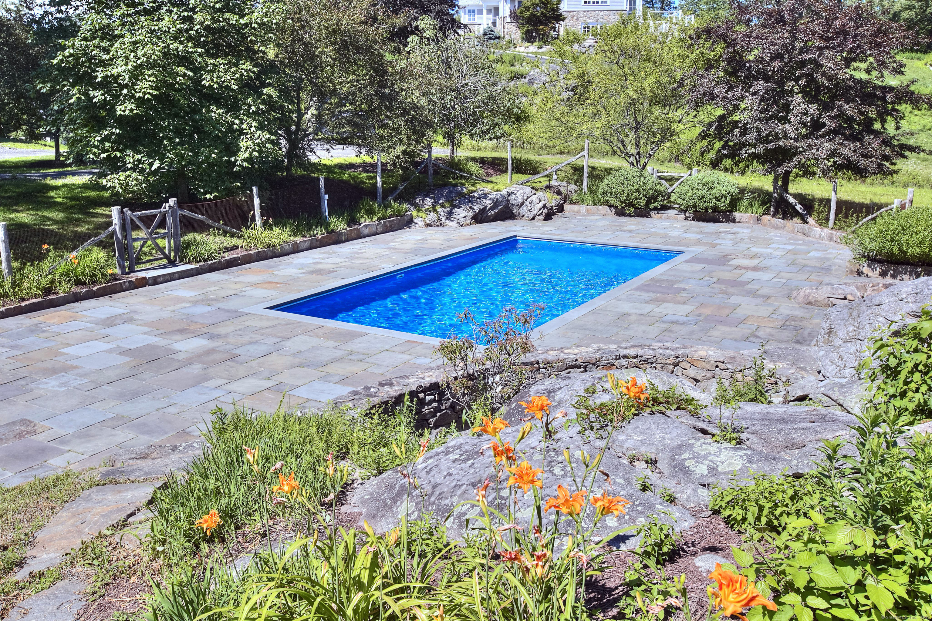 27 Rogues Ridge Road Weston, CT 06883 - Photo 35 of 39 a view of a swimming pool with an outdoor space and seating area