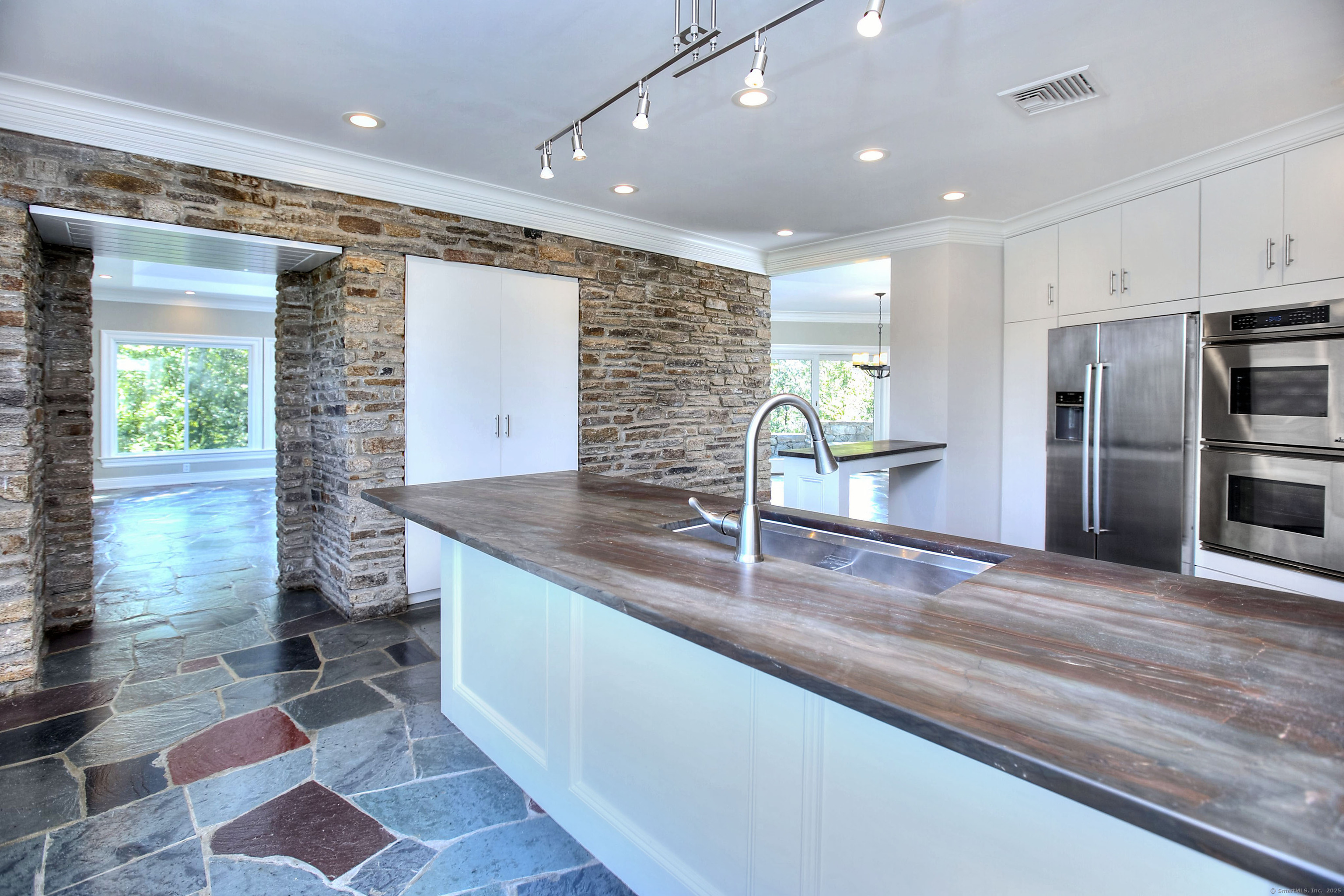 27 Rogues Ridge Road Weston, CT 06883 - Photo 6 of 39 a kitchen with stainless steel appliances granite countertop a sink and a refrigerator
