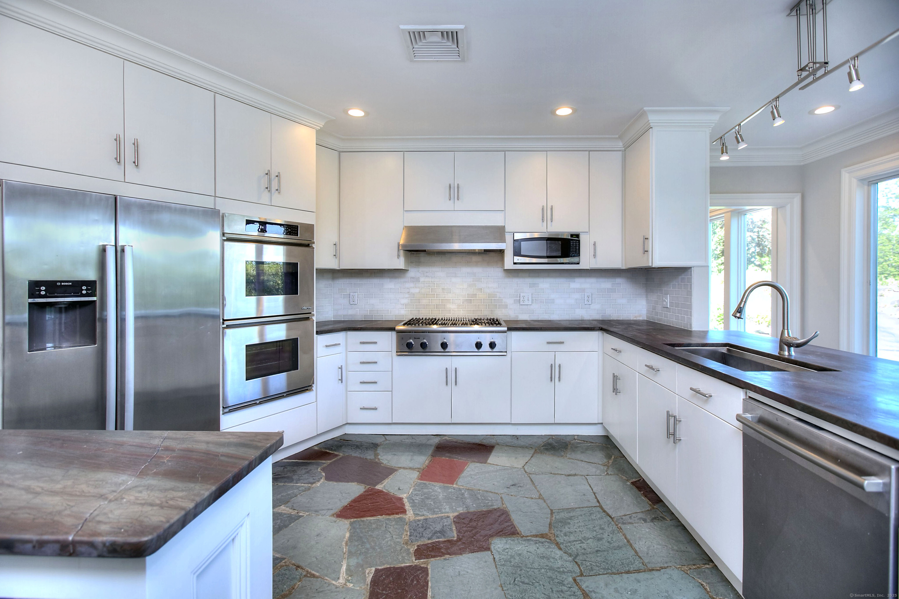 27 Rogues Ridge Road Weston, CT 06883 - Photo 8 of 39 a kitchen with stainless steel appliances granite countertop a sink stove and refrigerator