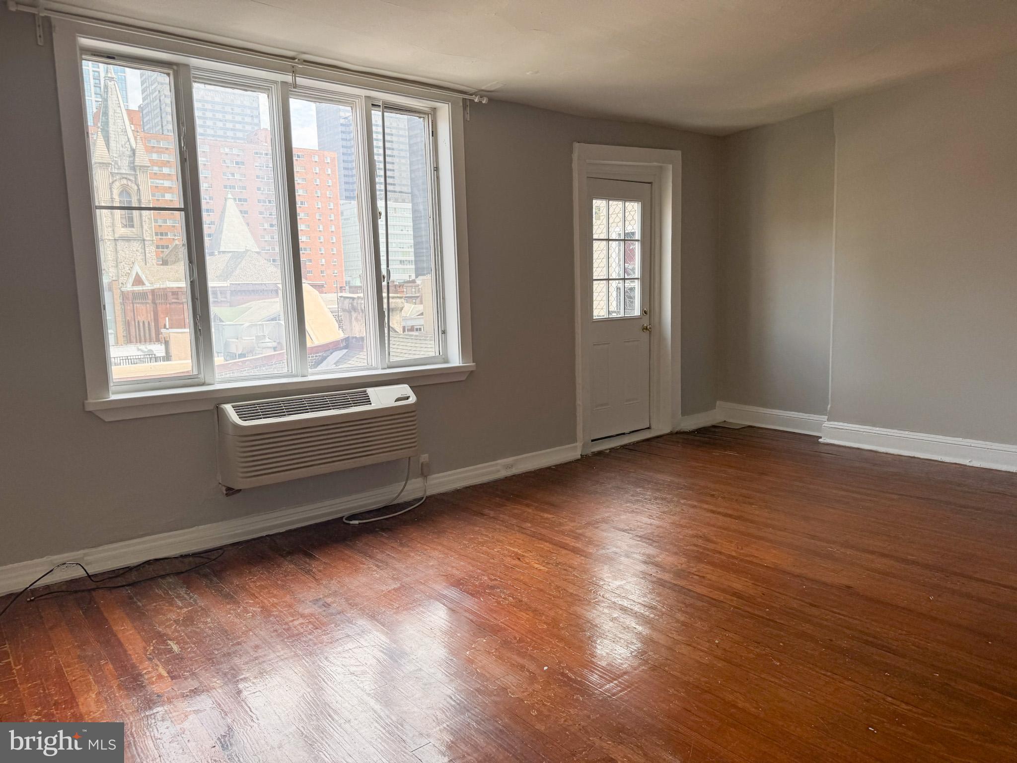 2125 Walnut Street, Unit 4 Philadelphia, PA 19103 - Photo 5 of 12 a view of an empty room with wooden floor and a window