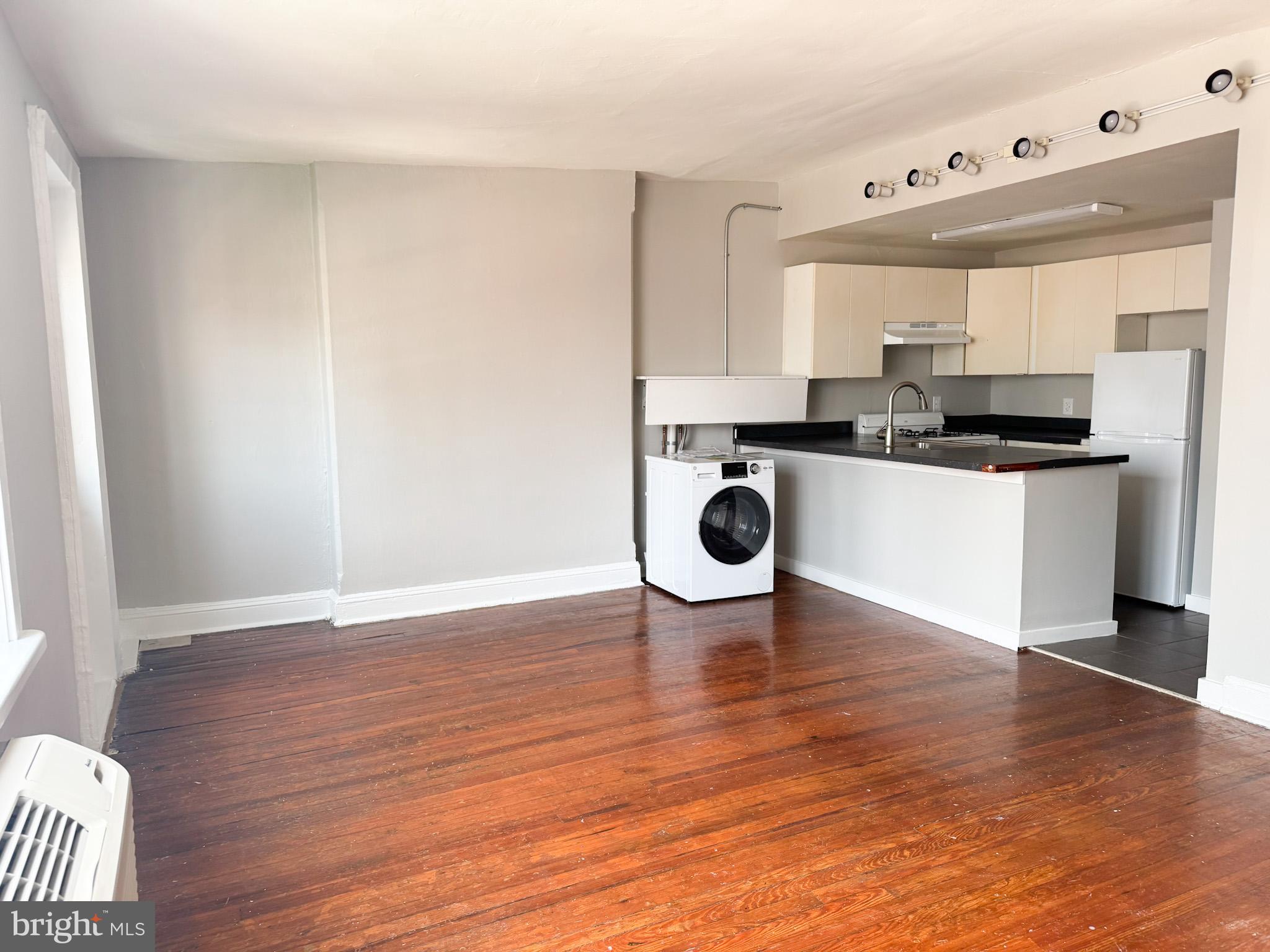 2125 Walnut Street, Unit 4 Philadelphia, PA 19103 - Photo 6 of 12 a kitchen with stainless steel appliances a white counter top a stove a sink and a refrigerator
