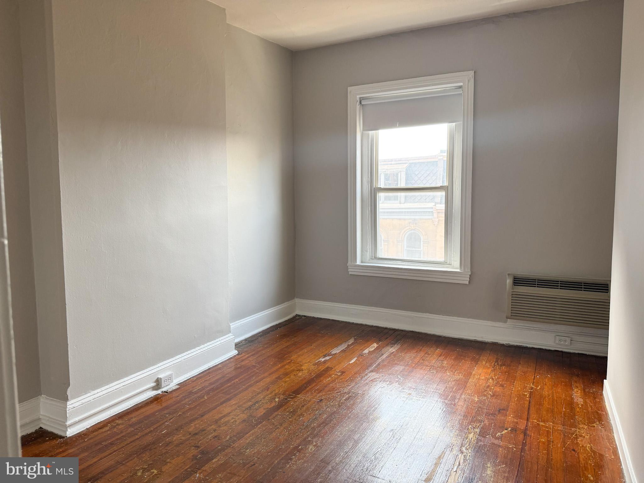 2125 Walnut Street, Unit 4 Philadelphia, PA 19103 - Photo 9 of 12 a view of an empty room with wooden floor and a window