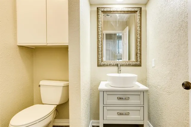 a bathroom with a sink mirror and toilet