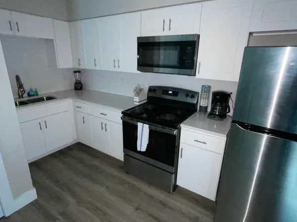 a kitchen with a refrigerator stove and white cabinets
