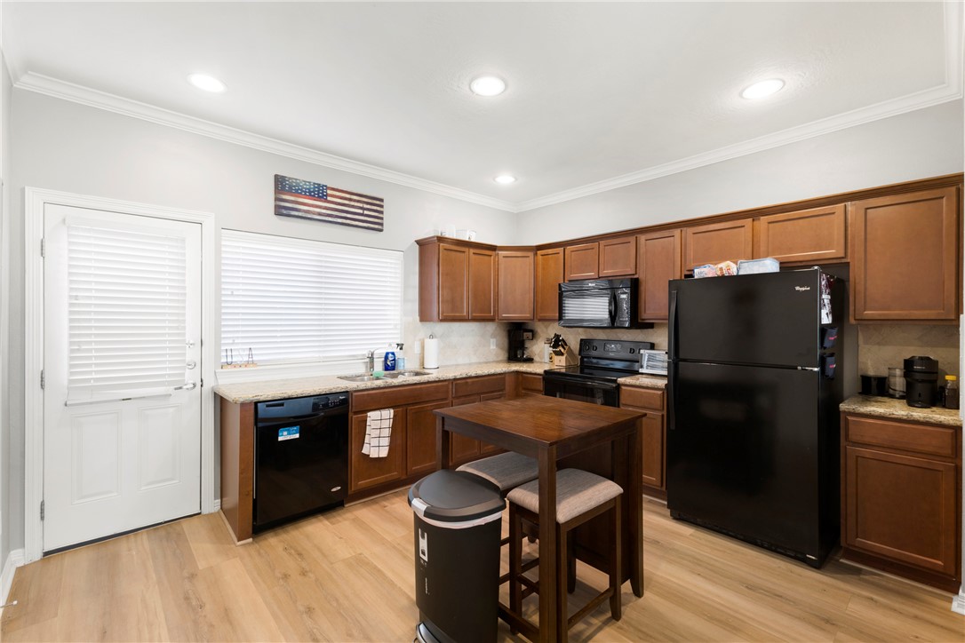 1198 Jones-Butler Road, Unit 3114 College Station, TX 77840 - Photo 3 of 13 a kitchen with stainless steel appliances a refrigerator a sink a stove a dining table and chairs