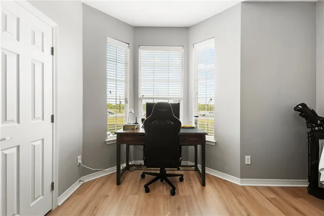 a view of a workspace with furniture and a window