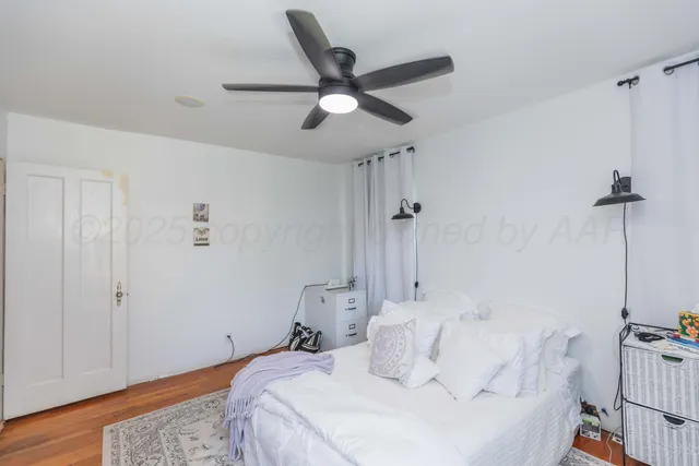 a bedroom with a bed and a ceiling fan
