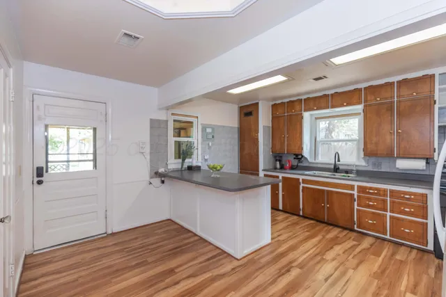 a kitchen with stainless steel appliances granite countertop wooden floors and sink