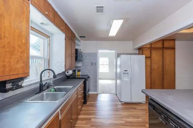 a kitchen with refrigerator cabinets and wooden floor