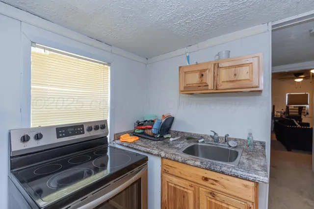 a kitchen with stainless steel appliances granite countertop a sink a stove and cabinets