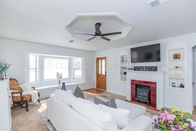 a living room with furniture a fireplace and a flat screen tv