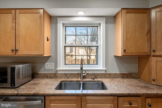 a kitchen with stainless steel appliances granite countertop a refrigerator a stove top oven a sink and dishwasher