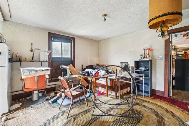 a living room with furniture a flat screen tv and a refrigerator