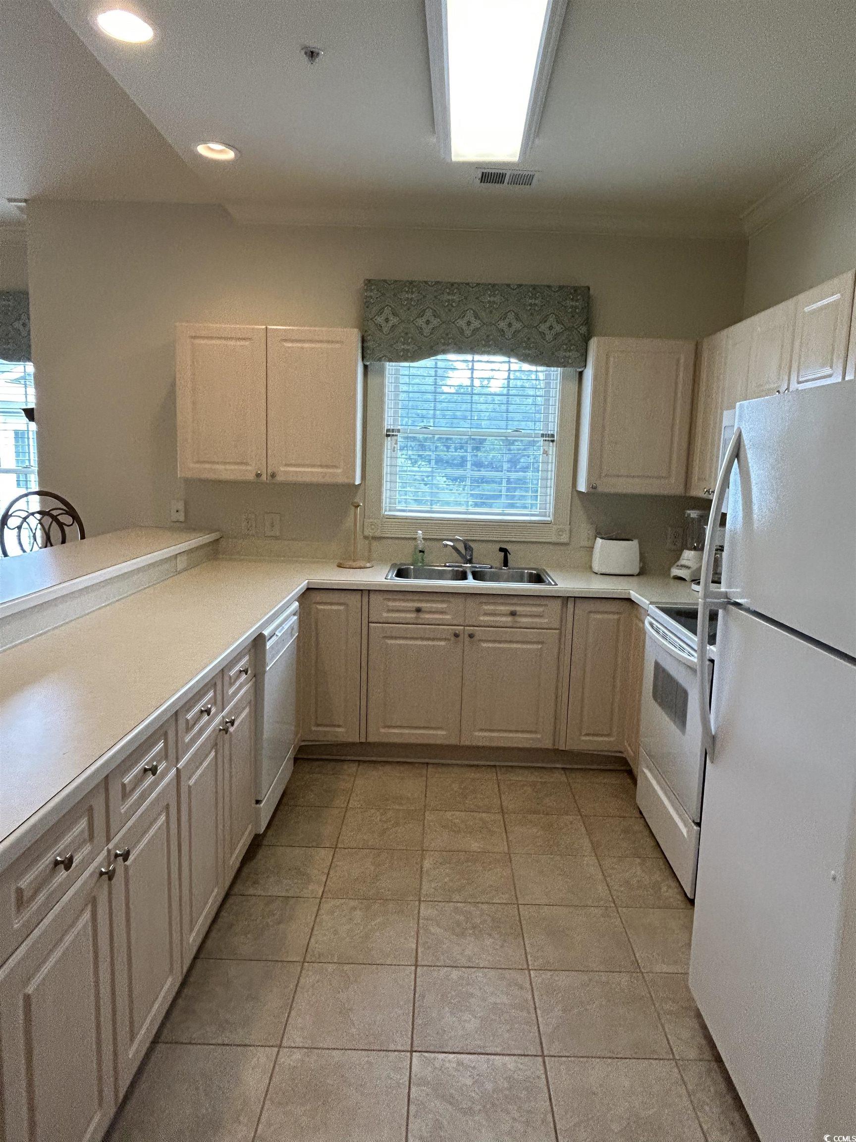 4893 Magnolia Pointe Lane, Unit 305 Myrtle Beach, SC 29577 - Photo 11 of 36 Kitchen with crown molding, sink, light tile patterned flooring, and white appliances