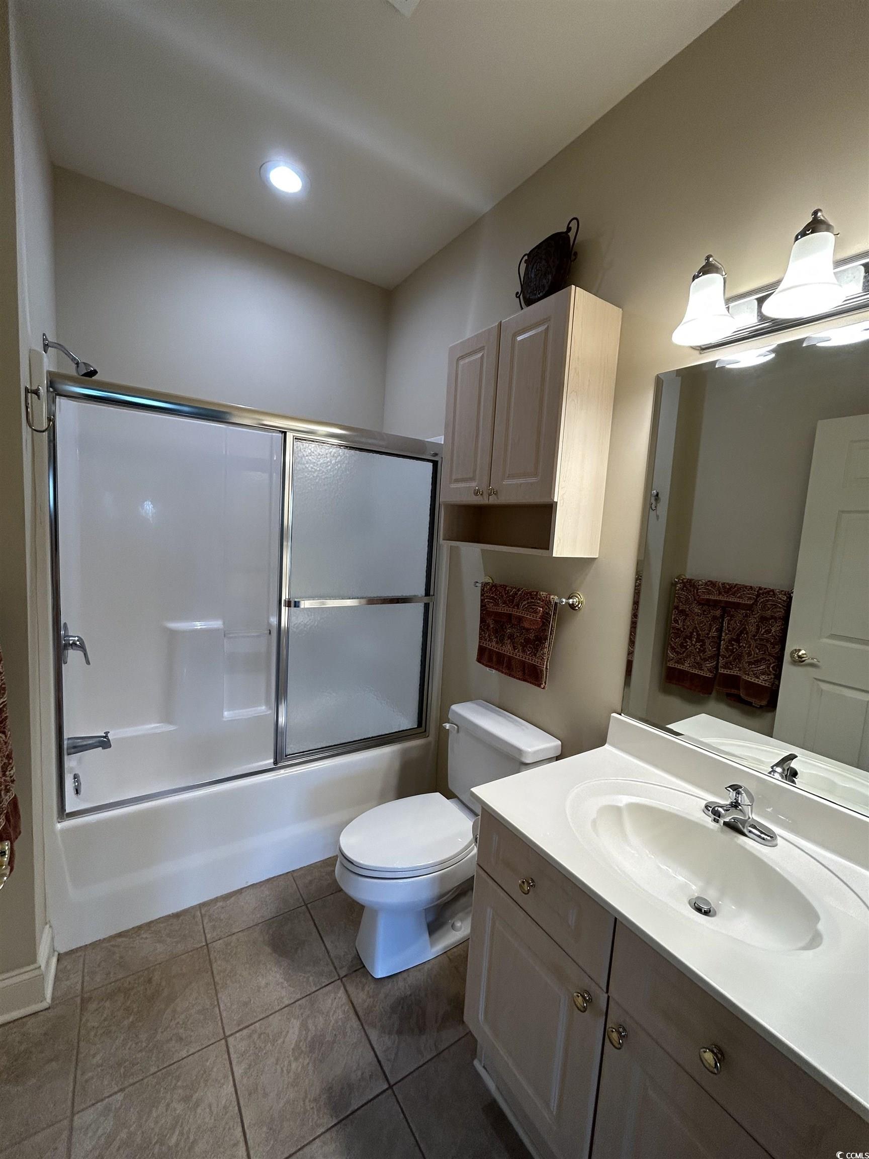 4893 Magnolia Pointe Lane, Unit 305 Myrtle Beach, SC 29577 - Photo 20 of 36 Full bathroom with tile patterned flooring, vanity, toilet, and bath / shower combo with glass door