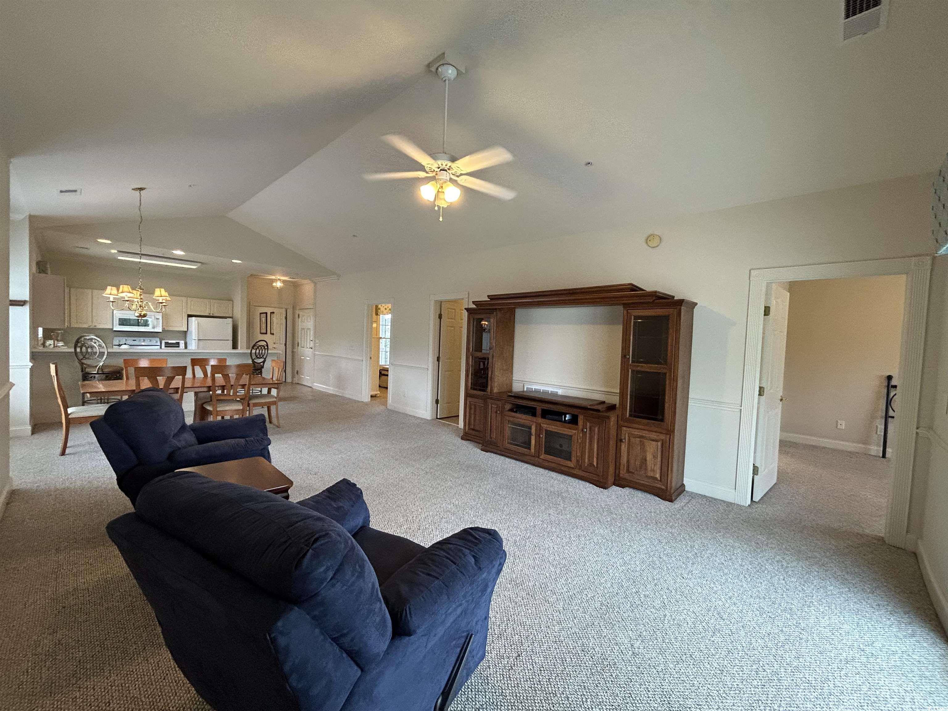 4893 Magnolia Pointe Lane, Unit 305 Myrtle Beach, SC 29577 - Photo 5 of 36 Carpeted living room with ceiling fan and vaulted ceiling