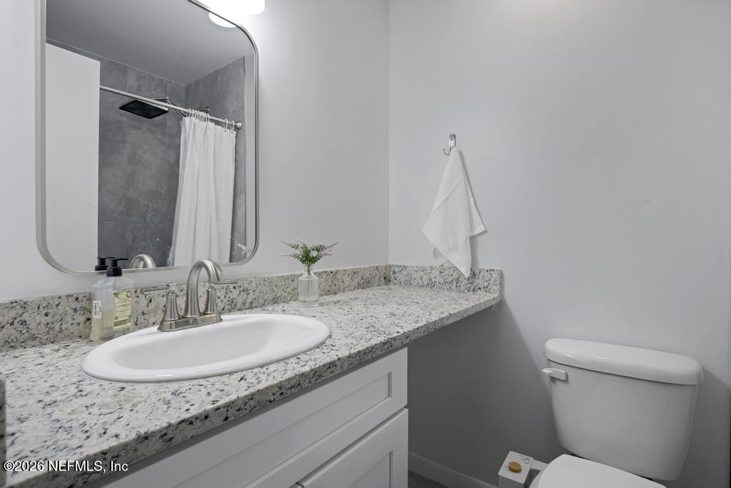 892 Trinidad Road Jacksonville, FL 32216 - Photo 23 of 37 a bathroom with a granite countertop sink and a mirror