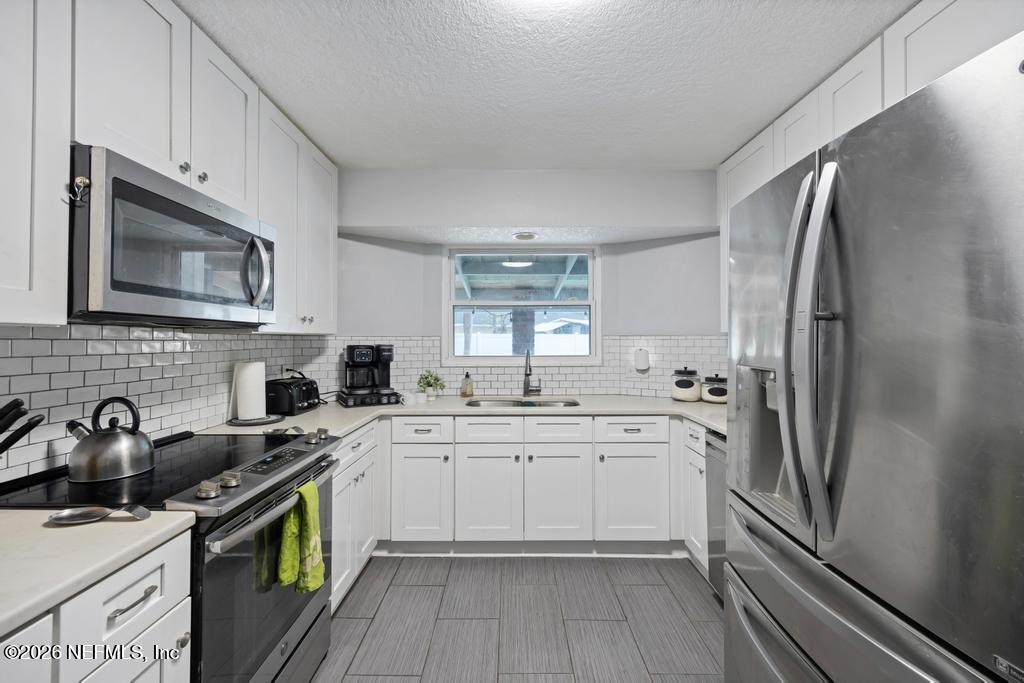 892 Trinidad Road Jacksonville, FL 32216 - Photo 8 of 37 a kitchen with a sink stove and refrigerator