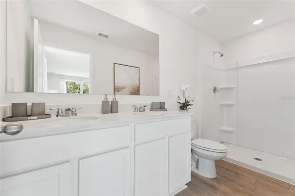 a bathroom with a double vanity sink toilet and shower