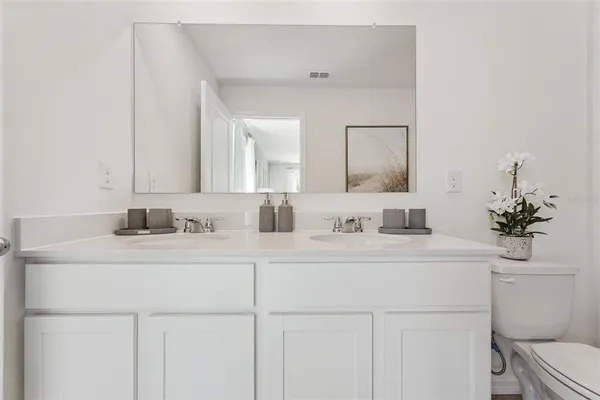 a bathroom with a sink a toilet and a mirror