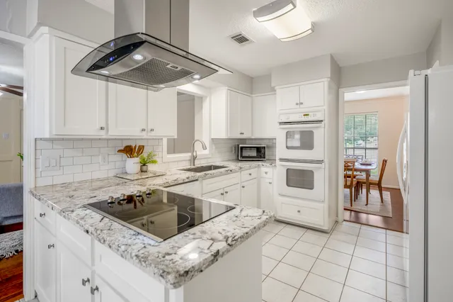 a kitchen with white cabinets and white appliances
