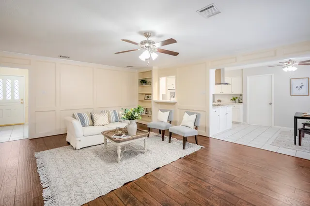 a living room with furniture and wooden floor