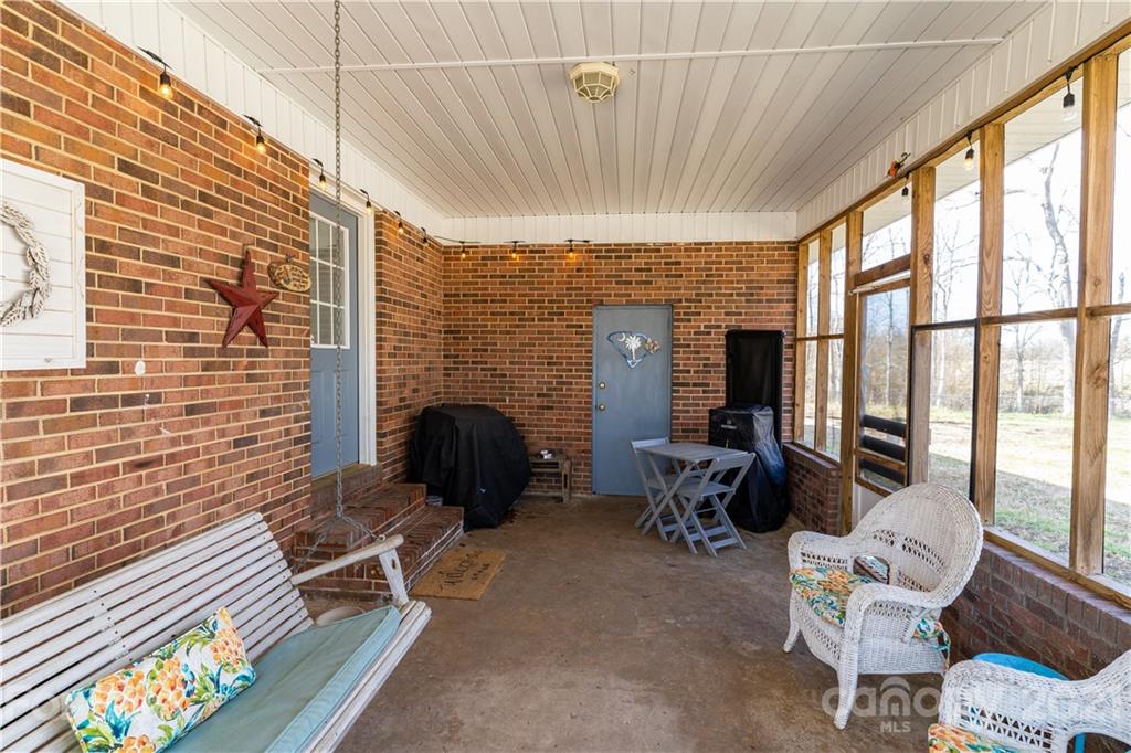 5743 Camp Creek Road Lancaster, SC 29720 - Photo 18 of 20 a living room with furniture a fireplace and large windows