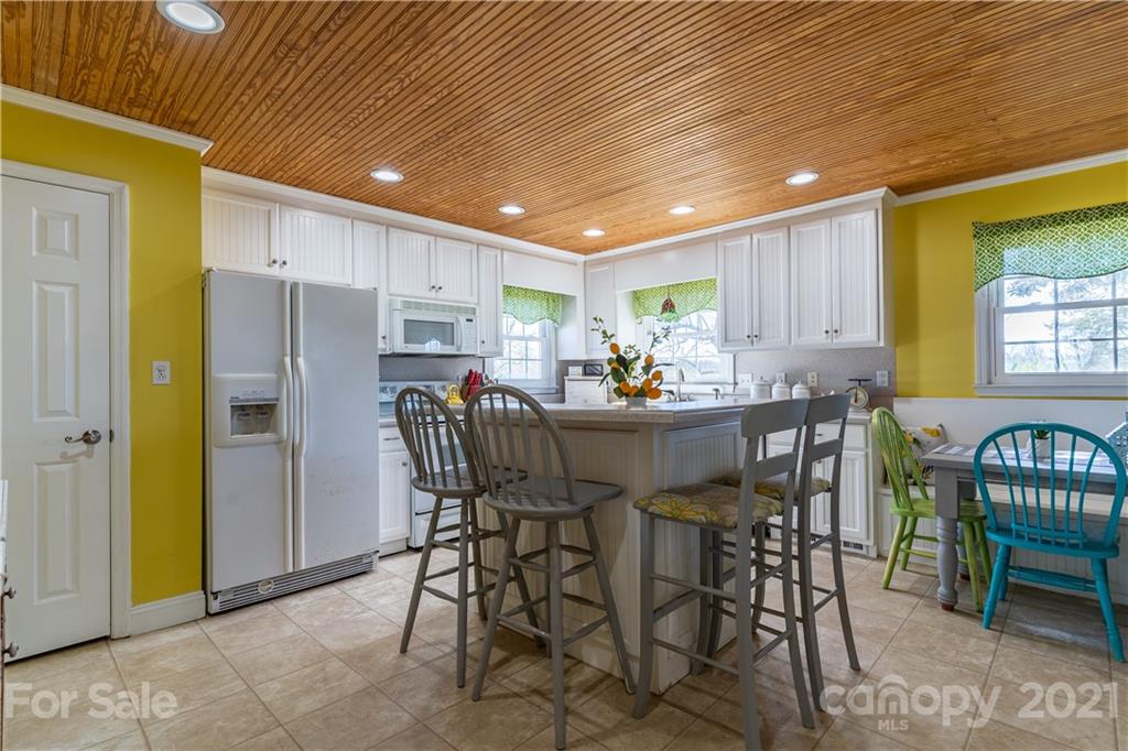 5743 Camp Creek Road Lancaster, SC 29720 - Photo 4 of 20 a kitchen with stainless steel appliances kitchen island granite countertop dining table chairs and a refrigerator