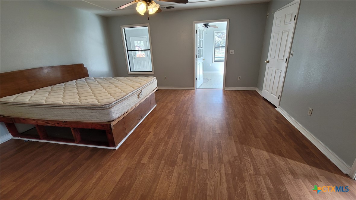 127-129 McAdams Road Goliad, TX 77963 - Photo 17 of 33 a spacious bedroom with a bed and wooden floor