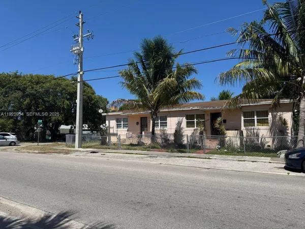 a front view of a house with palm trees