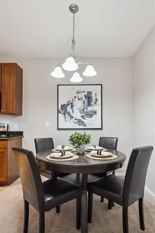 a view of a dining room with furniture and a chandelier fan