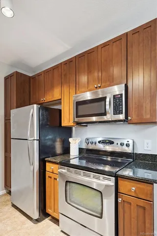 a kitchen with stainless steel appliances granite countertop a sink stove and cabinets