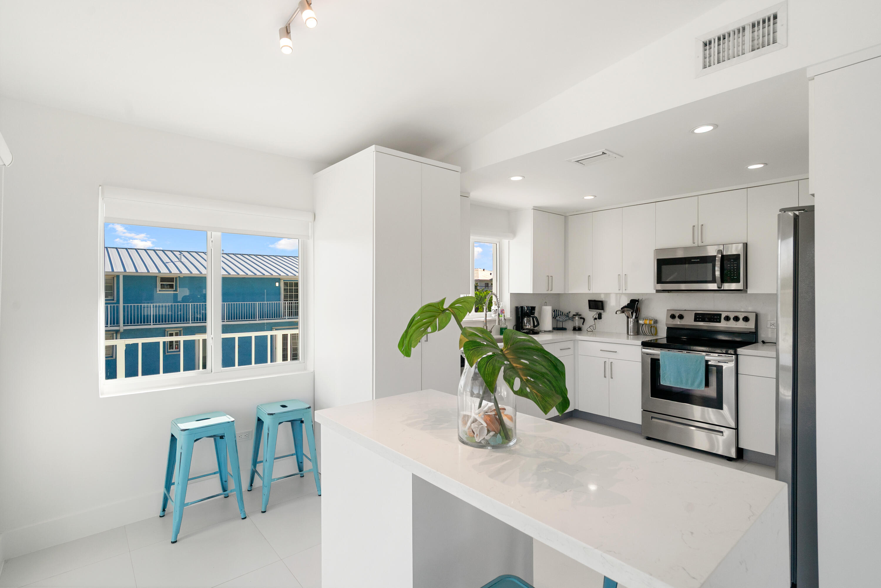 204 La Paloma Road Key Largo, FL 33037 - Photo 17 of 35 a kitchen with kitchen island granite countertop a sink cabinets and stainless steel appliances