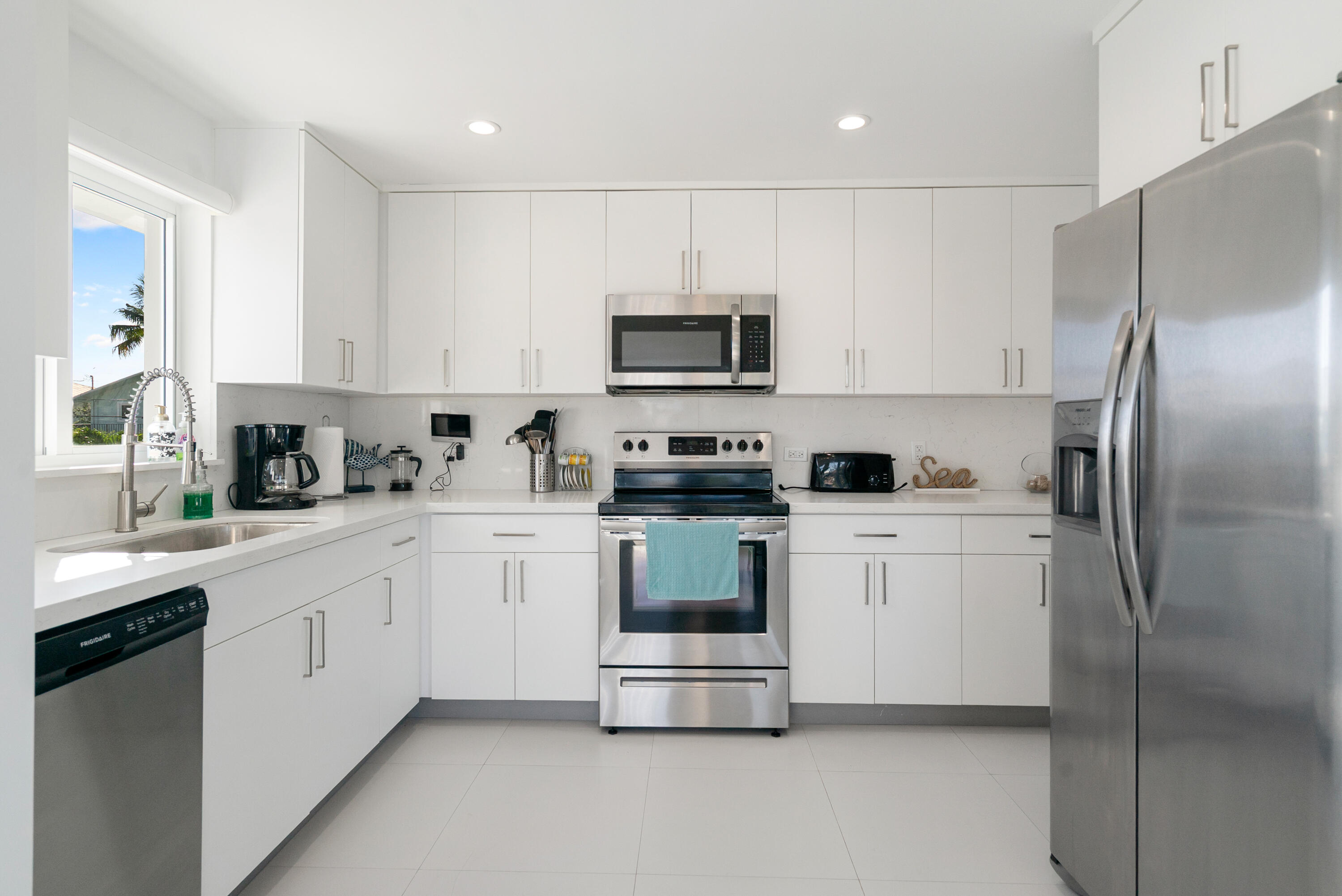204 La Paloma Road Key Largo, FL 33037 - Photo 18 of 35 a kitchen with stainless steel appliances granite countertop a refrigerator a stove a sink and a microwave