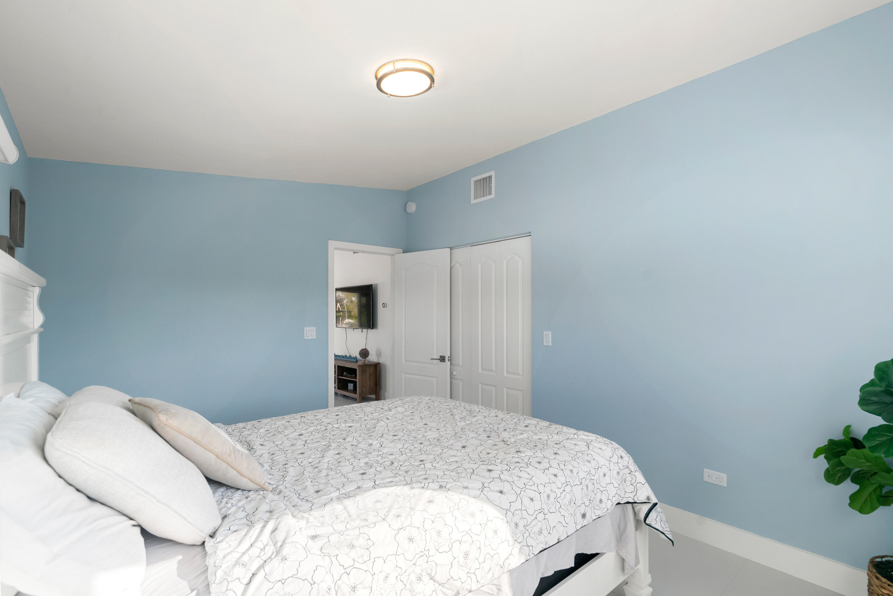 204 La Paloma Road Key Largo, FL 33037 - Photo 22 of 35 a bedroom with a bed and a potted plant