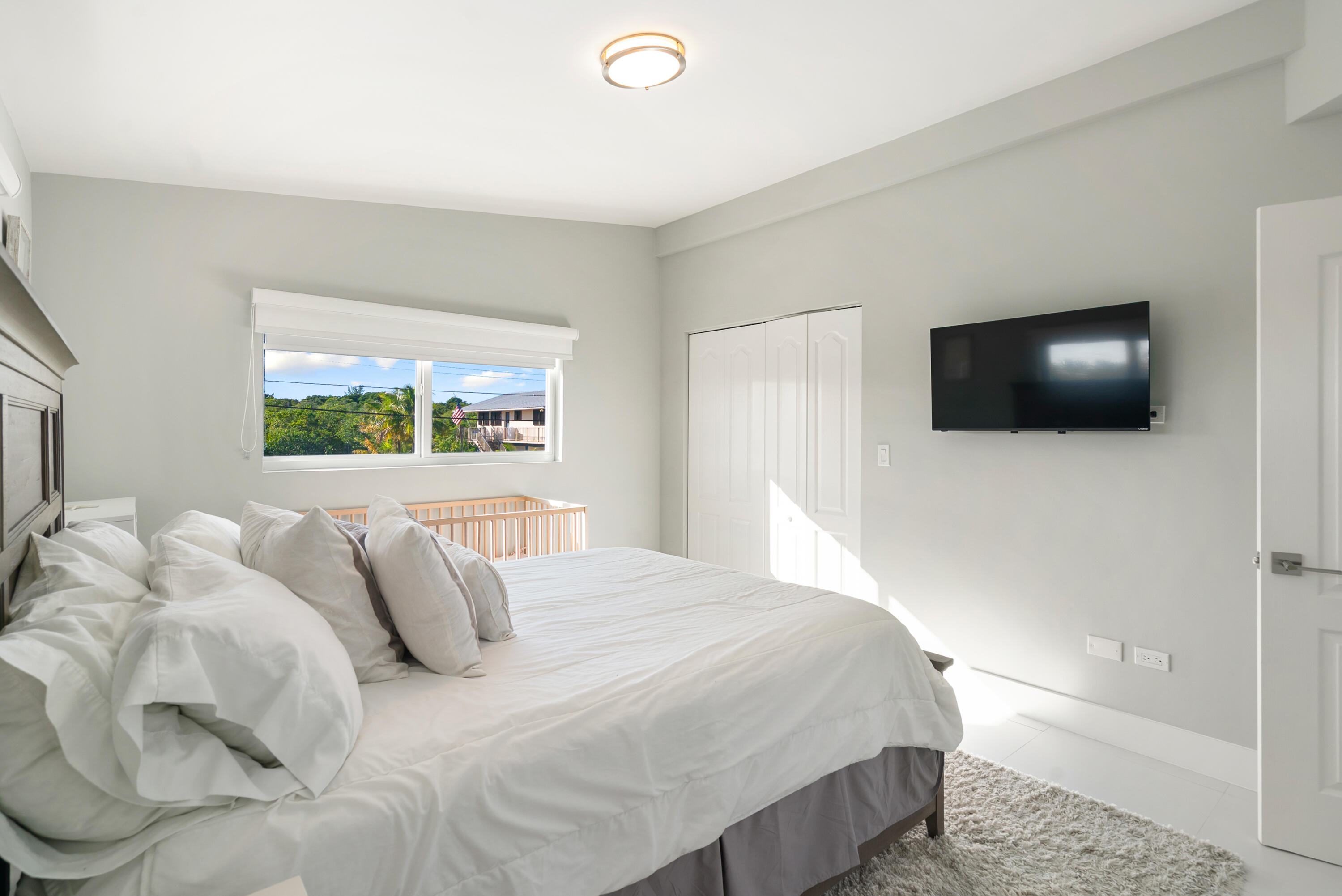 204 La Paloma Road Key Largo, FL 33037 - Photo 25 of 35 a bedroom with a bed and a flat screen tv