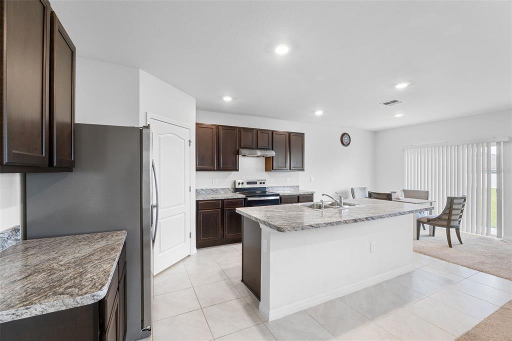 821 Sun Burst Road Winter Haven, FL 33880 - Photo 14 of 86 a kitchen with stainless steel appliances granite countertop a sink stove and refrigerator