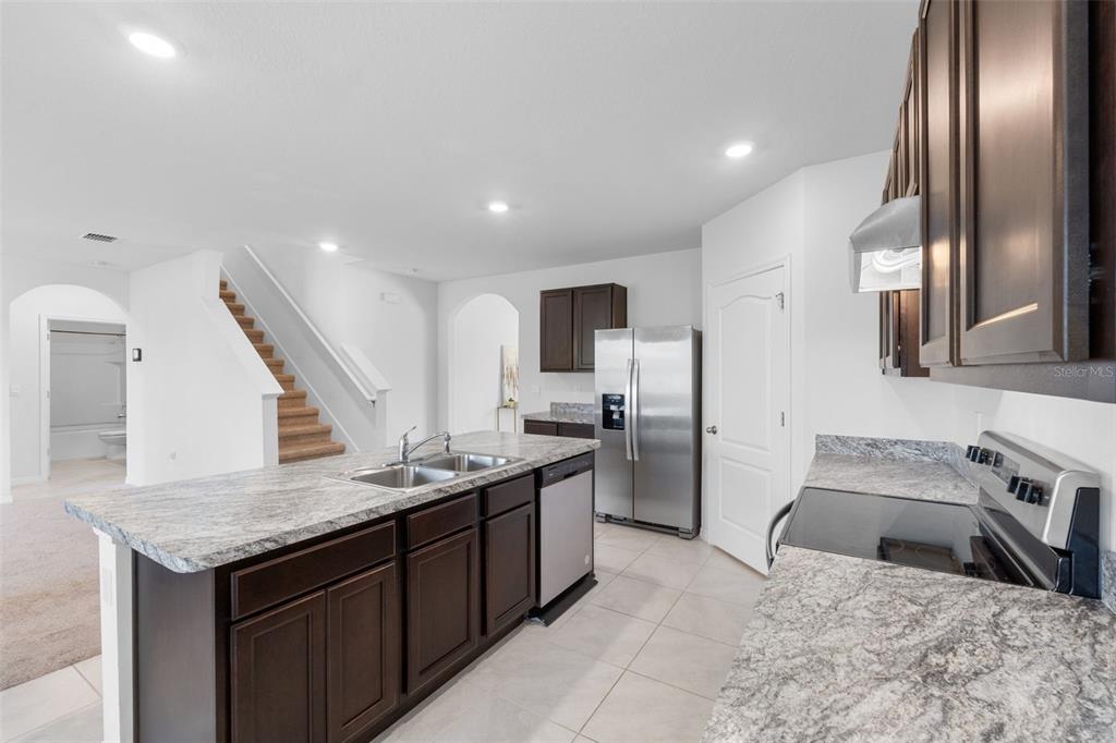 821 Sun Burst Road Winter Haven, FL 33880 - Photo 18 of 86 a kitchen with stainless steel appliances granite countertop a sink stove and refrigerator
