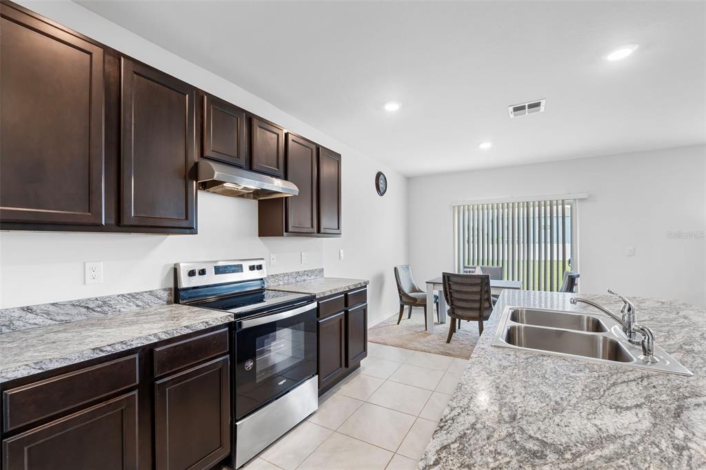 821 Sun Burst Road Winter Haven, FL 33880 - Photo 19 of 86 a kitchen with stainless steel appliances granite countertop a sink stove and refrigerator