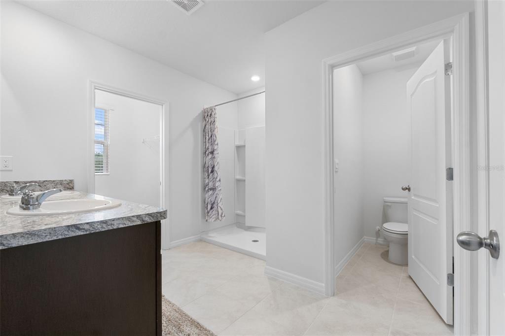 821 Sun Burst Road Winter Haven, FL 33880 - Photo 42 of 86 a bathroom with a granite countertop sink a toilet and shower