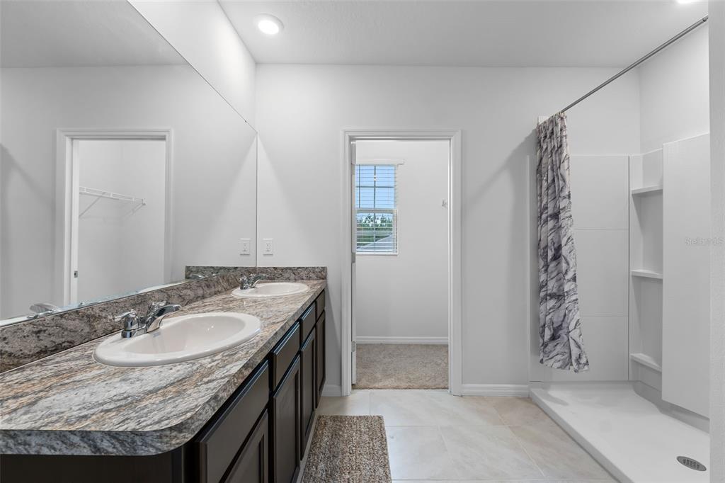 821 Sun Burst Road Winter Haven, FL 33880 - Photo 43 of 86 a bathroom with a granite countertop sink a toilet and shower